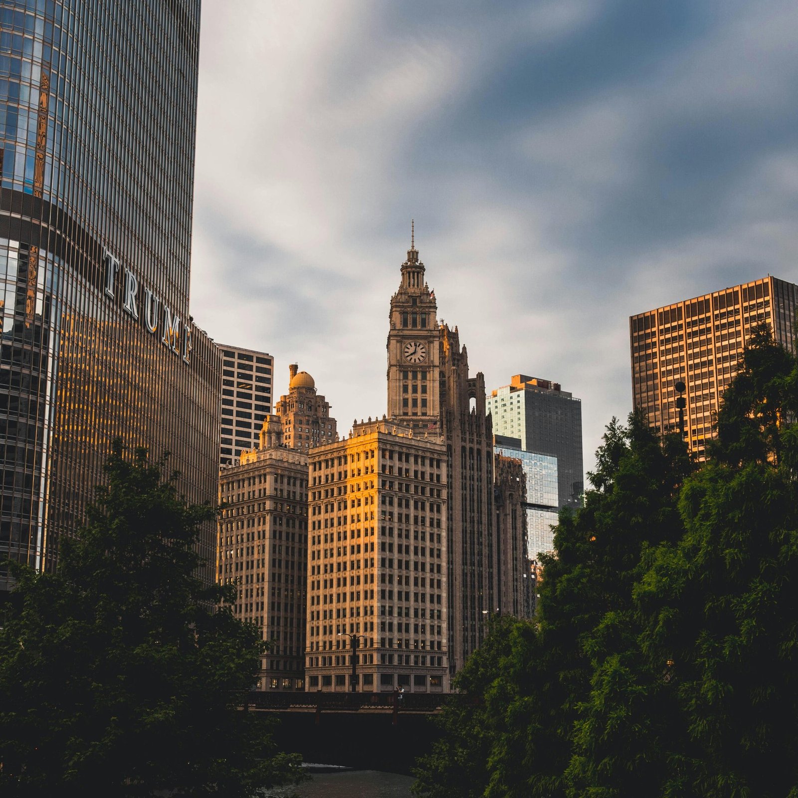 Capture of a city skyline with a prominent clock tower and skyscrapers at sunset, highlighting urban architecture.