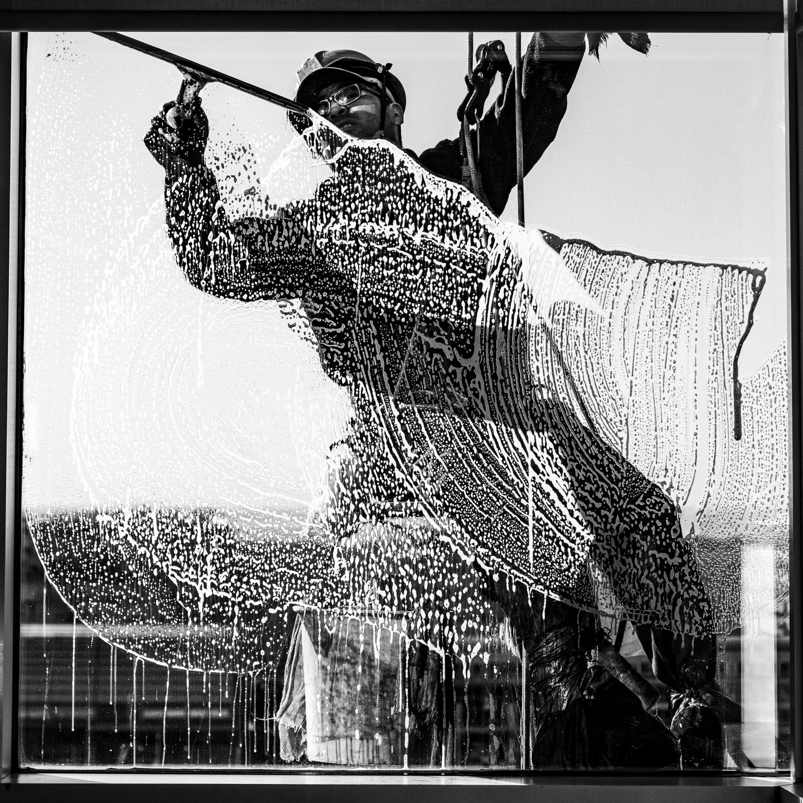 High-rise window cleaner captured in monochrome, showcasing urban city life in Buenos Aires.