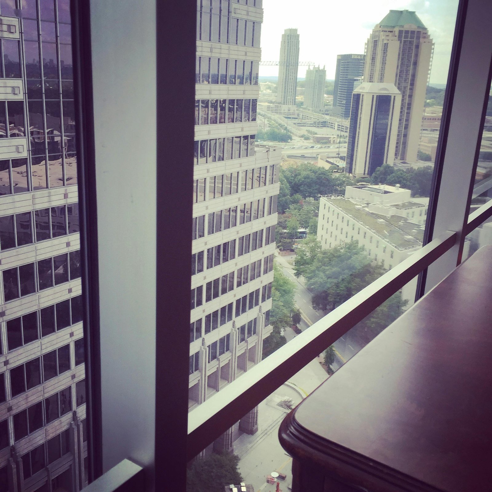 Window view of modern city skyline and skyscrapers from a high-rise office.