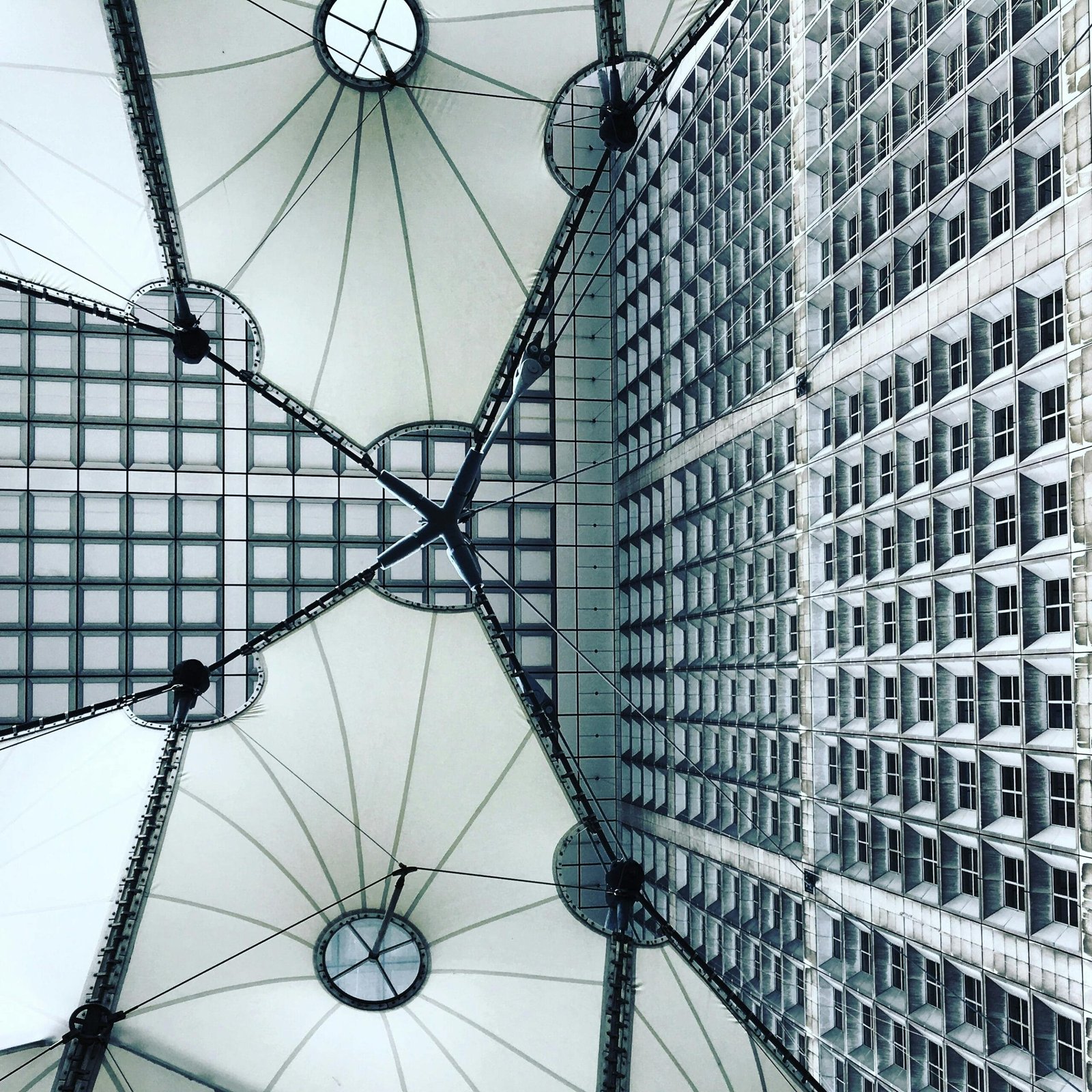 Intricate modern architecture view of La Défense, highlighting the geometric ceiling and glass facade.