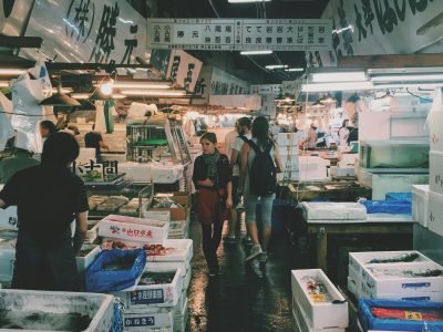 Vibrant fish market scene in Tokyo, showcasing stalls and shoppers.