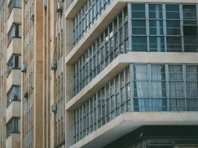 Low angle shot of a modern office building facade in Cali, Colombia with glass windows and air conditioning units.