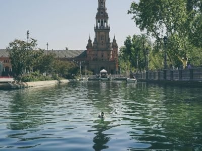 Stunning view of Plaza de España with a peaceful canal and lush greenery in Seville.