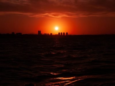 Captivating sunset with a red sky over Fortaleza skyline and sea.