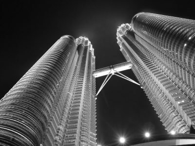A dramatic night view of the iconic Petronas Twin Towers in Kuala Lumpur, Malaysia.