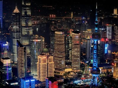 A stunning aerial view of Shanghai's cityscape at night featuring the illuminated Oriental Pearl Tower.