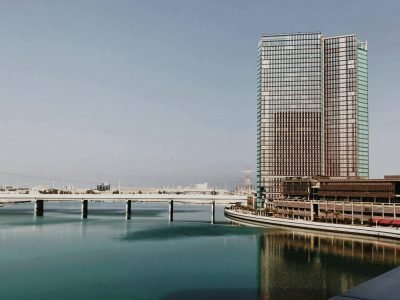 Elegant modern architecture in Abu Dhabi with clear sky reflecting on calm waters.