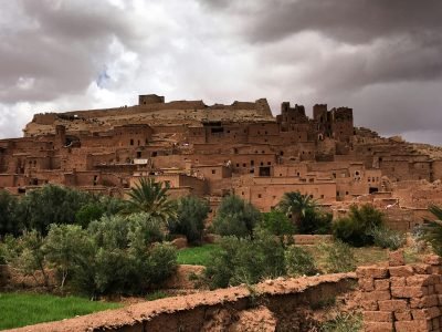 Explore the ancient clay architecture of Aït Ben Haddou under dramatic skies, a UNESCO World Heritage Site.