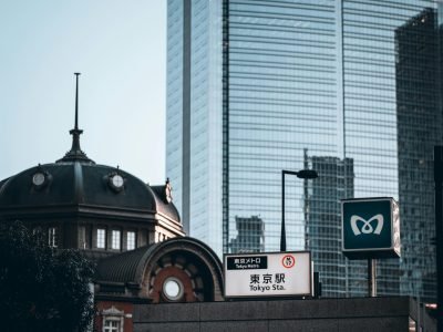 View of Tokyo Station with a modern skyscraper in the background, embodying urban contrast.