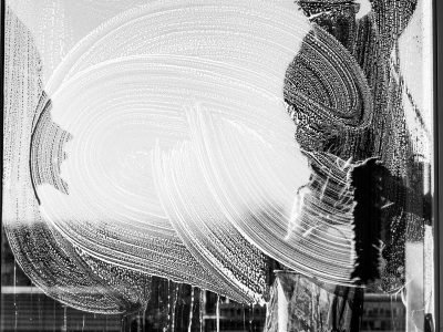 Black and white photo of a window cleaner with streaks on glass in Buenos Aires.