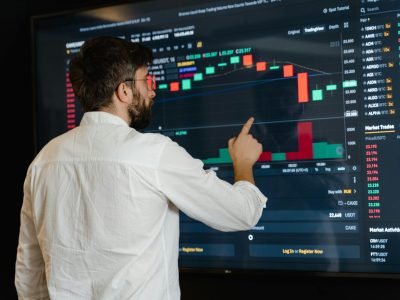 A man pointing towards a candlestick chart